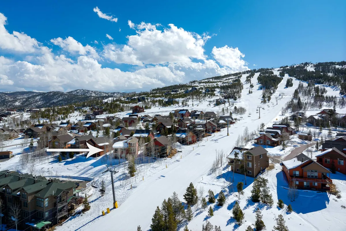 This view features rolling, snow-covered hills, ski slopes, neighboring houses, and pine trees. The scenery is both adventurous and serene, inviting guests to imagine walks and hikes with their pets through beautiful mountain terrain.